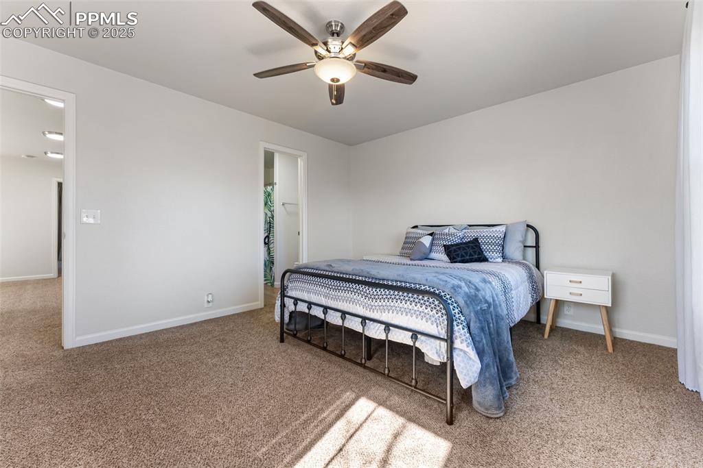Image 17 of 34: Bedroom with light carpet and a ceiling fan