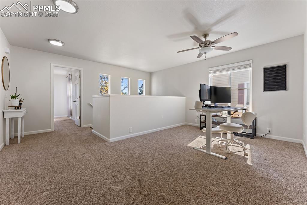 Image 20 of 34: Home office featuring light colored carpet and a ceiling fan