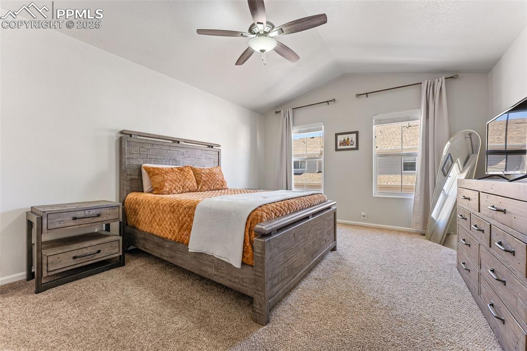 Image 22 of 34: Bedroom featuring light carpet, vaulted ceiling, and ceiling fan
