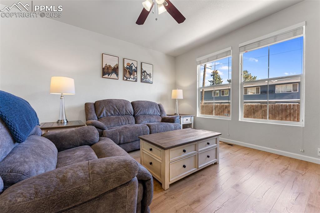 Image 4 of 34: Living room with light wood-type flooring and a ceiling fan