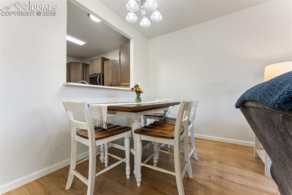 Image 7 of 34: Dining room with light wood-style floors and a chandelier