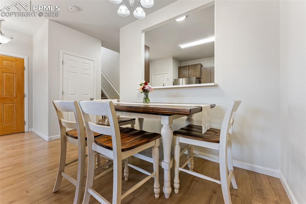 Image 8 of 34: Dining room featuring light wood-style floors, a chandelier, and stairs