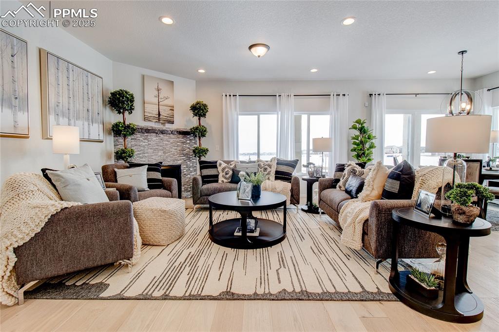 Image 10 of 32: Living area featuring recessed lighting, wood finished floors, and a firepl