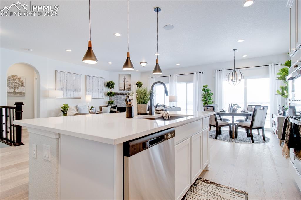 Image 13 of 32: Kitchen featuring arched walkways, a sink, light wood-type flooring, recess