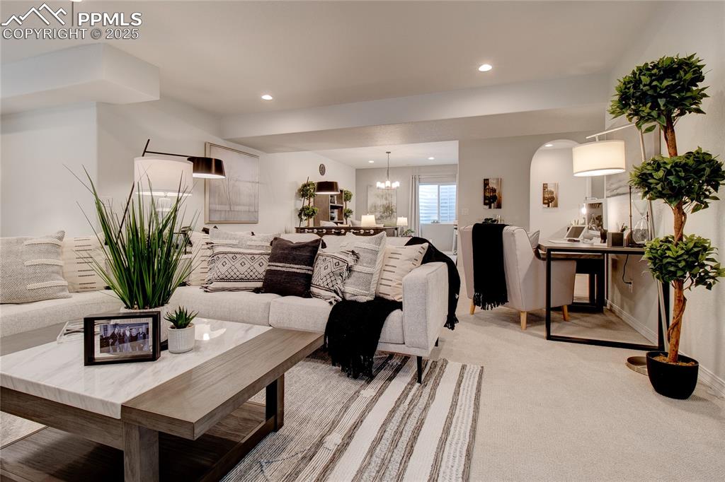 Image 26 of 32: Living area with recessed lighting, a chandelier, arched walkways, and ligh