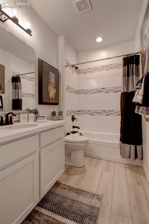 Image 30 of 32: Bathroom featuring wood finished floors, vanity, shower / bath combination 