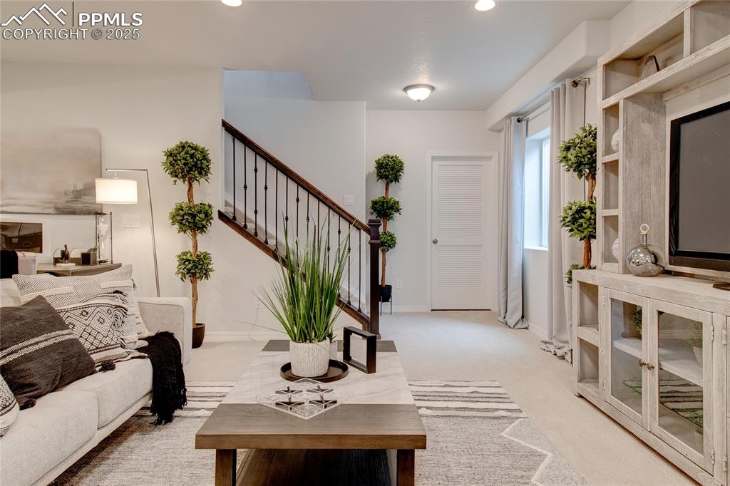 Image 32 of 32: Living area with recessed lighting, stairway, baseboards, and light colored