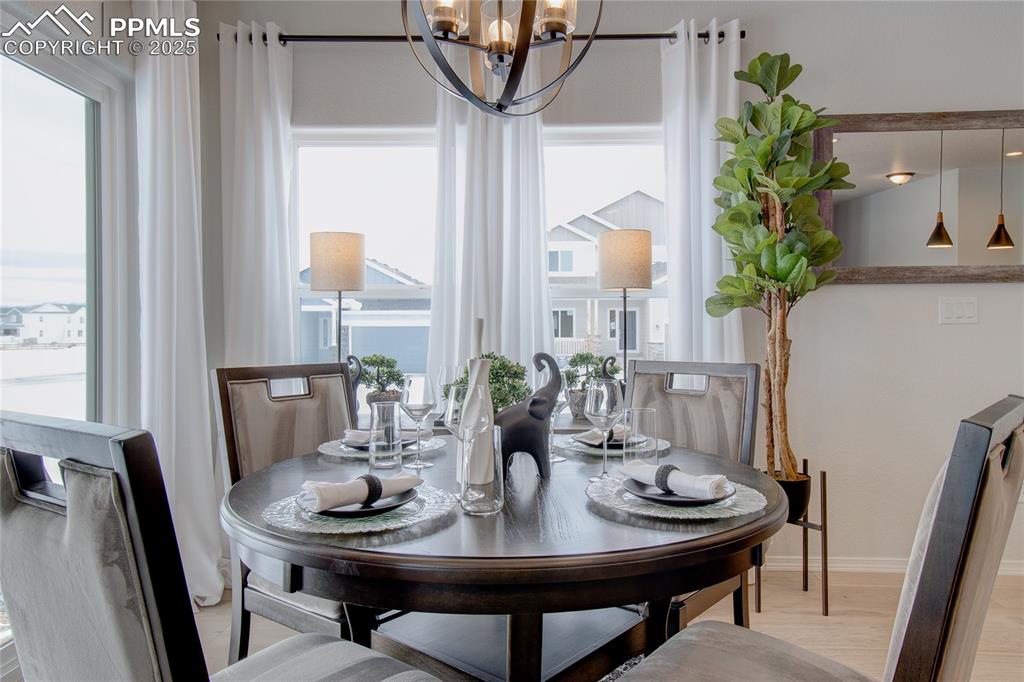 Image 9 of 32: Dining space featuring light wood-type flooring, baseboards, a chandelier, 