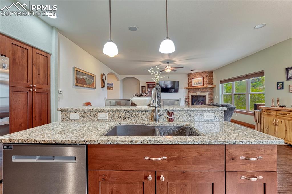 Image 12 of 43: Kitchen with appliances with stainless steel finishes, a ceiling fan, brown