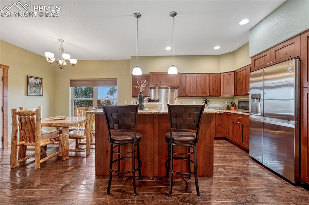 Image 16 of 43: Kitchen with appliances with stainless steel finishes, dark wood finished f