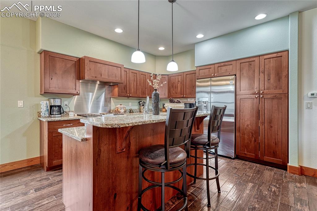 Image 17 of 43: Kitchen featuring stainless steel fridge with ice dispenser, dark wood-type