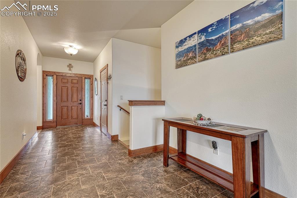 Image 2 of 43: Foyer entrance featuring baseboards and stone finish floors
