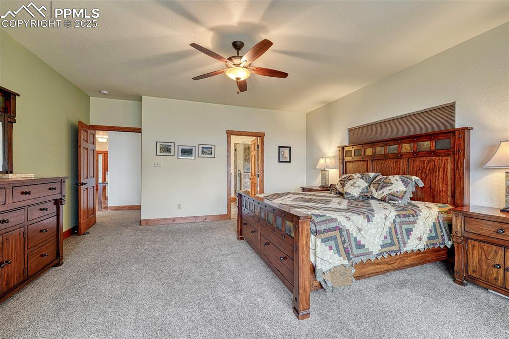 Image 22 of 43: Bedroom with light colored carpet, a ceiling fan, and baseboards