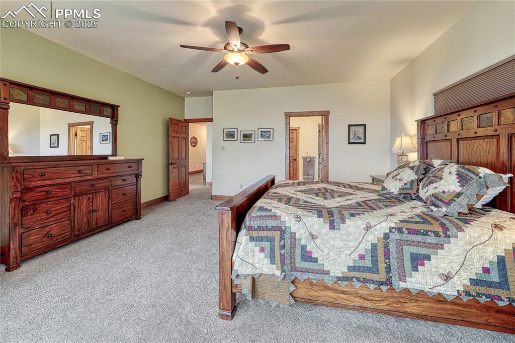 Image 23 of 43: Bedroom featuring light carpet, a ceiling fan, and ensuite bathroom