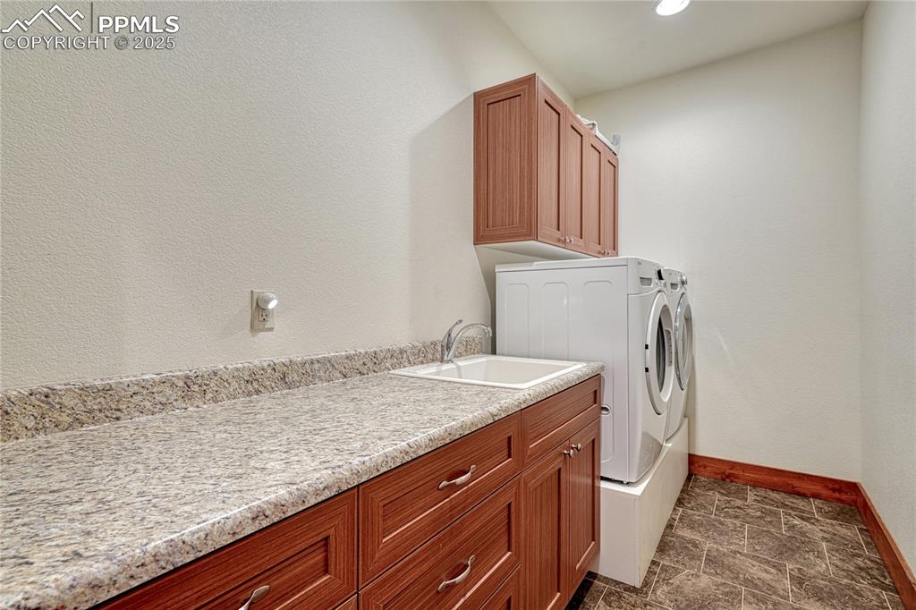 Image 35 of 43: Laundry room with baseboards, washer and clothes dryer, cabinet space, dark