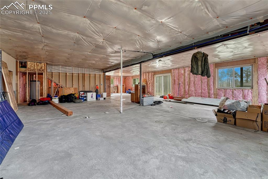 Image 39 of 43: Miscellaneous room featuring concrete flooring and water heater