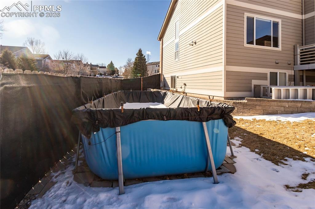 Image 47 of 50: Above-ground heated pool with an access to finished full bathroom in the ba