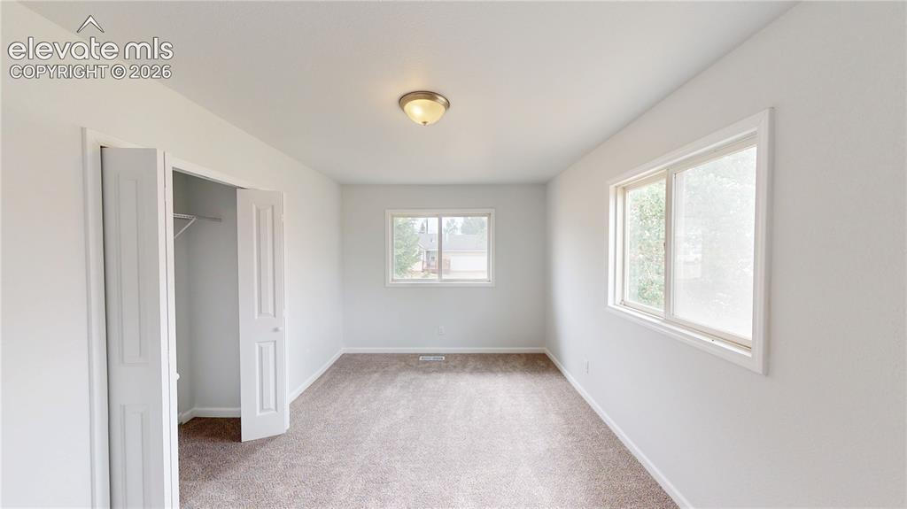 Image 12 of 16: Neutral-toned carpeting with white walls and trim