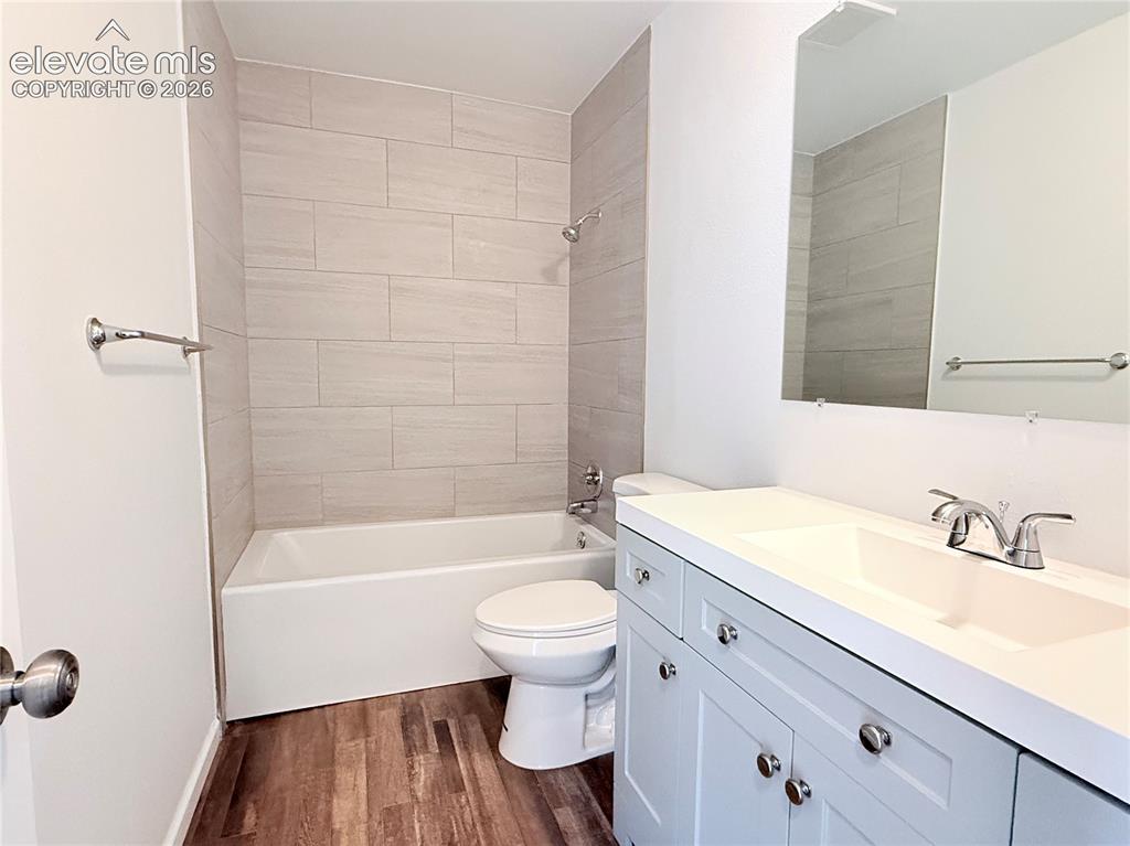 Image 13 of 16: Bathroom featuring a white bathtub, tiled shower surround, wood-finish floo
