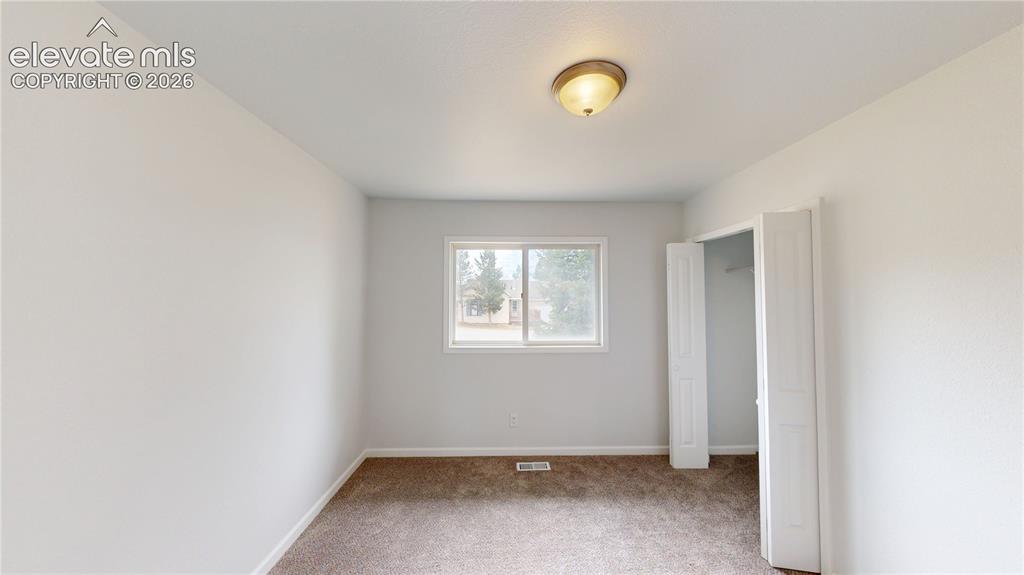 Image 15 of 16: Neutral wall tones, carpeted flooring, a ceiling-mounted light fixture, a w