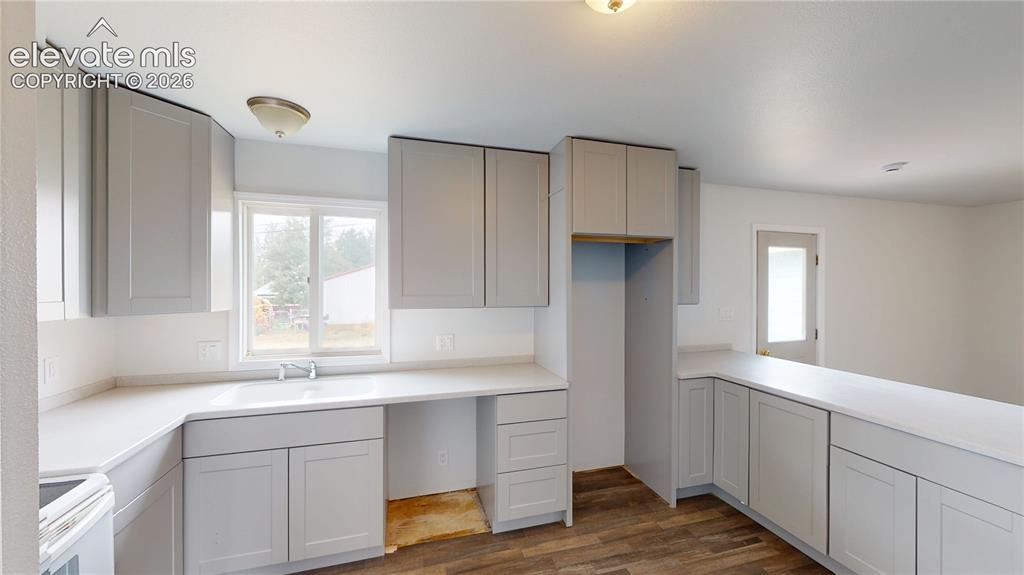 Image 3 of 16: Spacious kitchen featuring extensive light gray cabinetry, white countertop