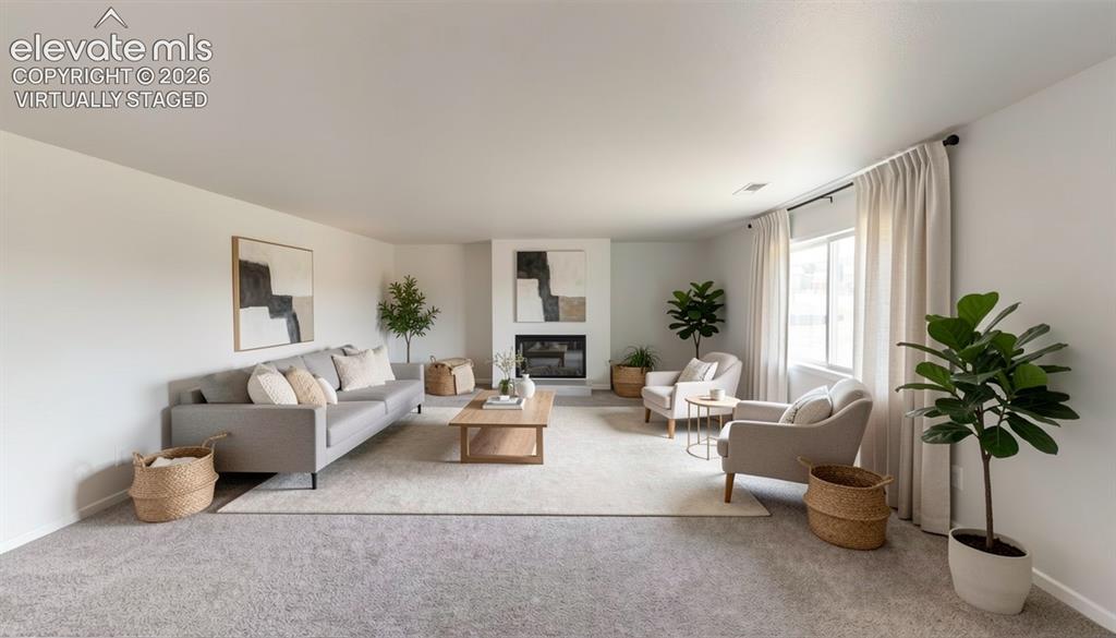Image 7 of 16: virtually staged.Carpeted living area featuring a fireplace with a white ma