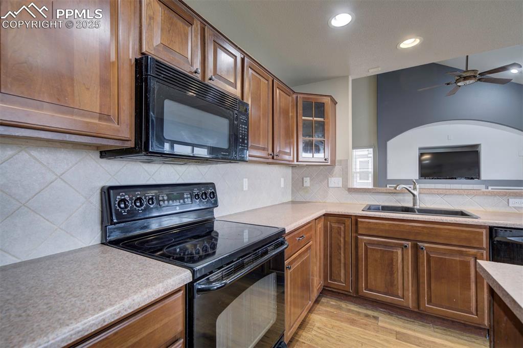 Image 14 of 43: Kitchen featuring black appliances, a sink, light wood finished floors, a c
