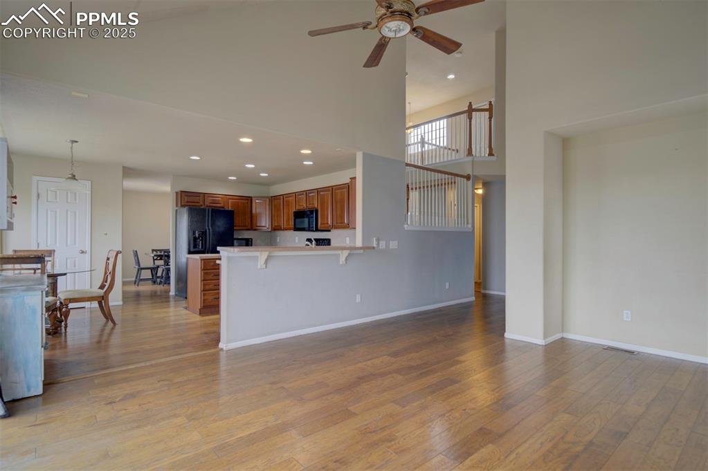 Image 20 of 43: Living area featuring high vaulted ceiling, light wood-type flooring, a cei