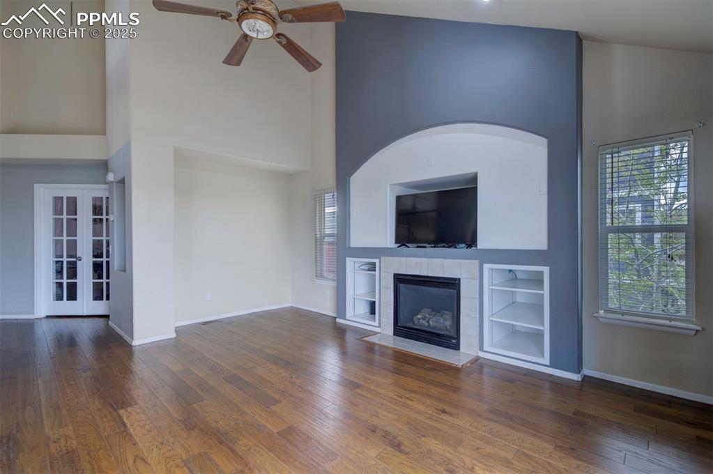 Image 21 of 43: Unfurnished living room featuring ceiling fan, hardwood / wood-style floori