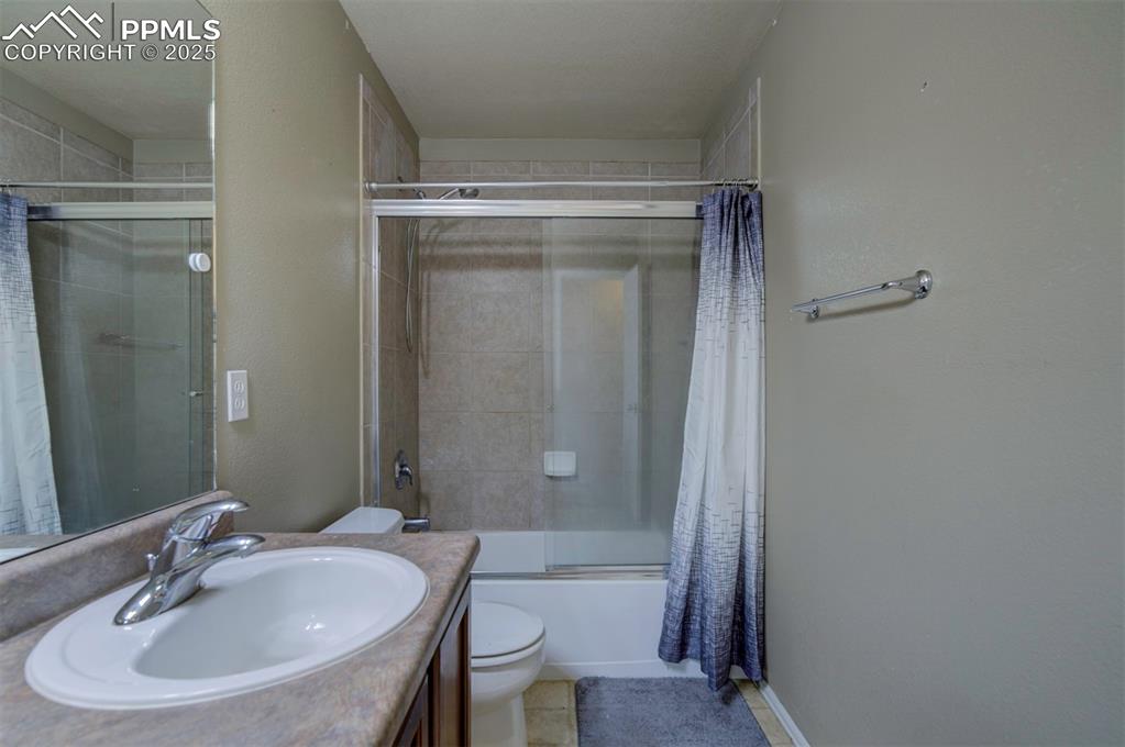 Image 29 of 43: Bathroom with toilet, combined bath / shower with glass door, and vanity