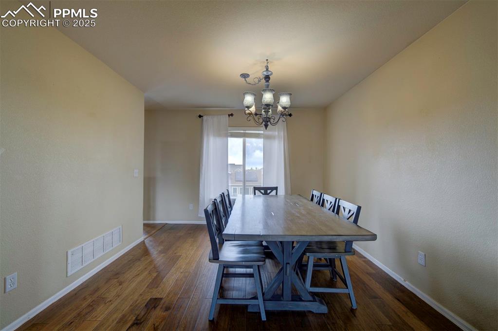 Image 4 of 43: Dining room featuring a chandelier, hardwood / wood-style floors, and baseb