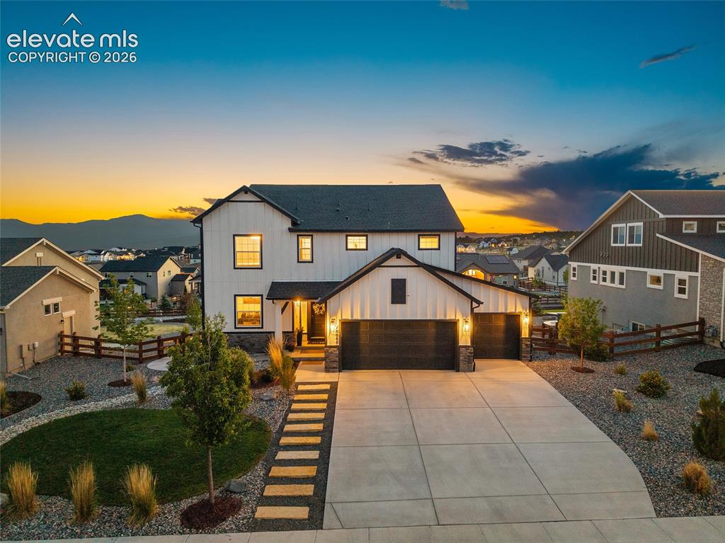 Caption: Contemporary farmhouse-style exterior with a two-car garage
