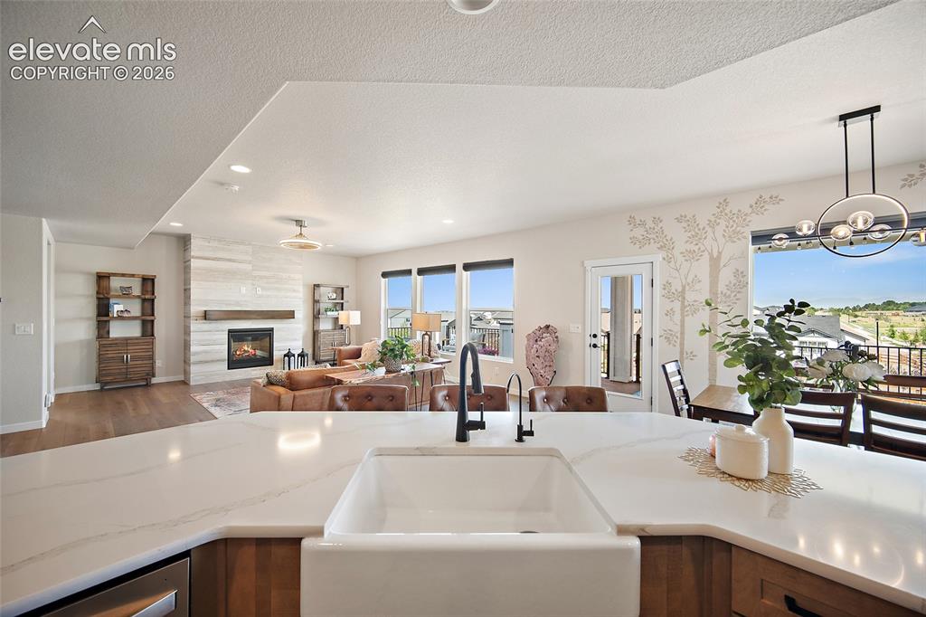 Image 13 of 47: Kitchen island with a farmhouse sink and black faucet, wood-finish cabinetr