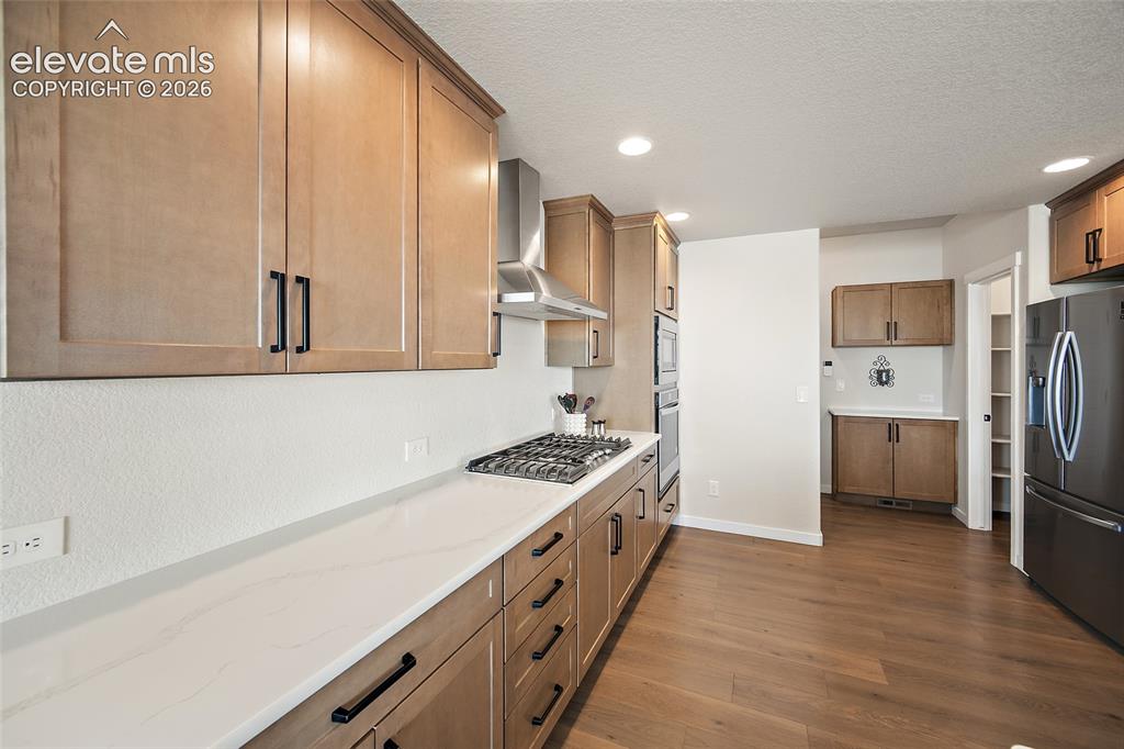 Image 16 of 47: Kitchen featuring light wood-finish cabinetry with matte black hardware, wh