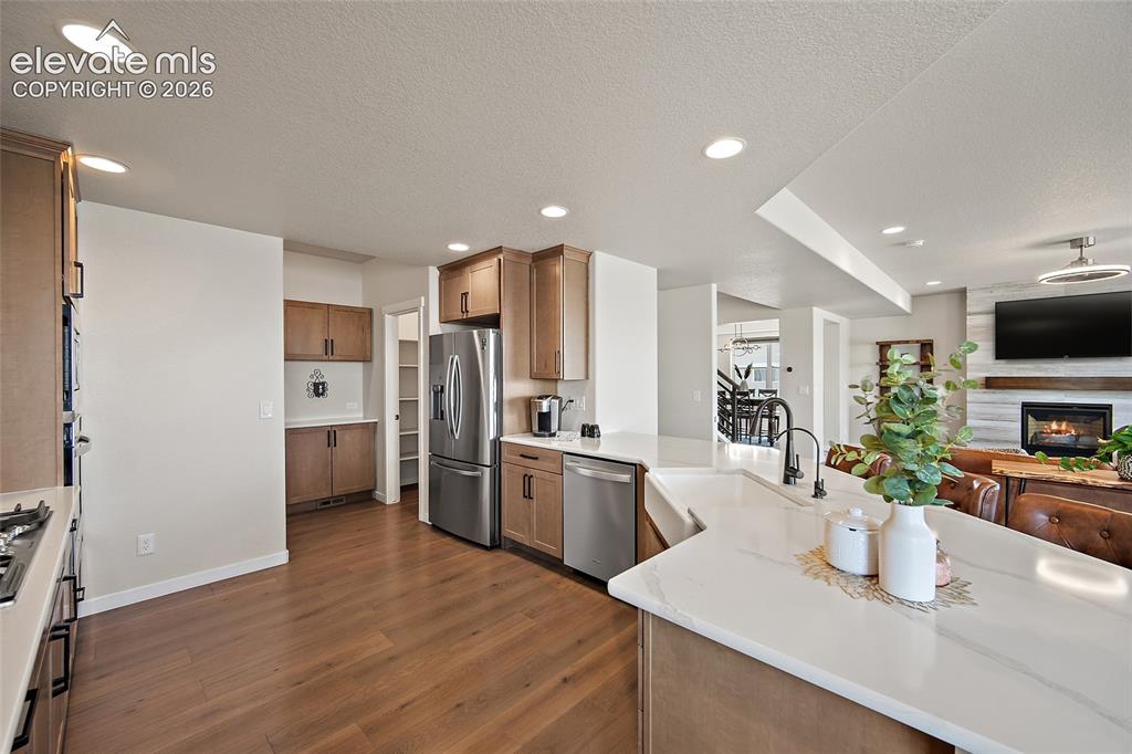 Image 17 of 47: Kitchen featuring wood-finish flooring, recessed lighting, wood cabinetry,