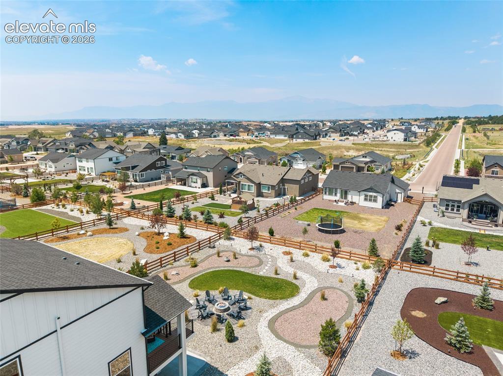 Image 24 of 47: Expansive landscaped property featuring a large patio, fire pit area, and m
