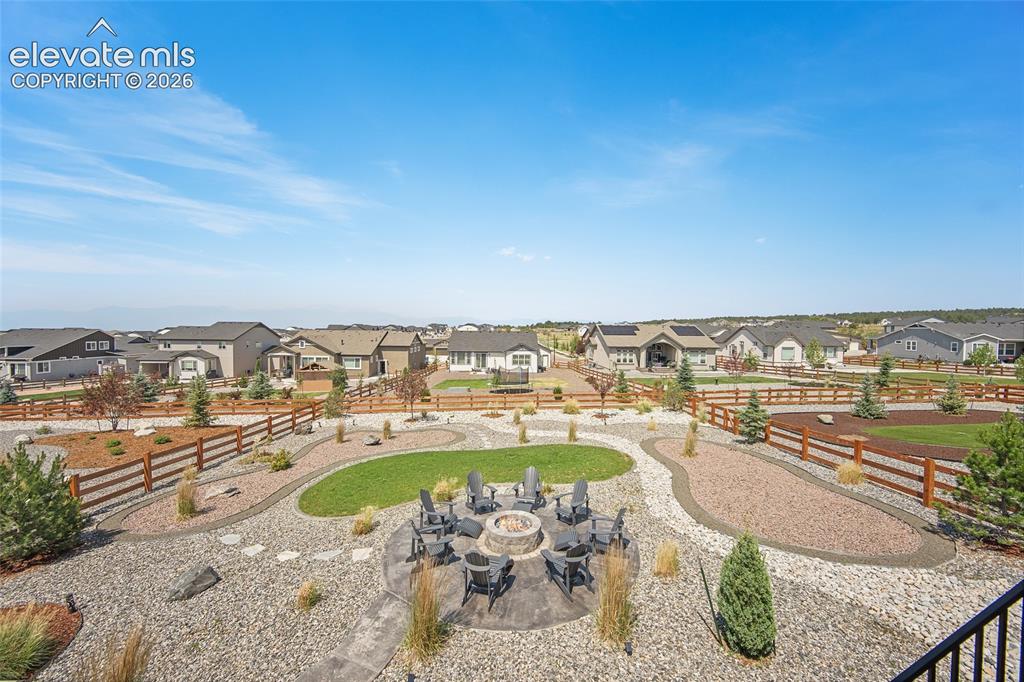 Image 26 of 47: Expansive backyard featuring a stone fire pit, gravel and grass landscaping