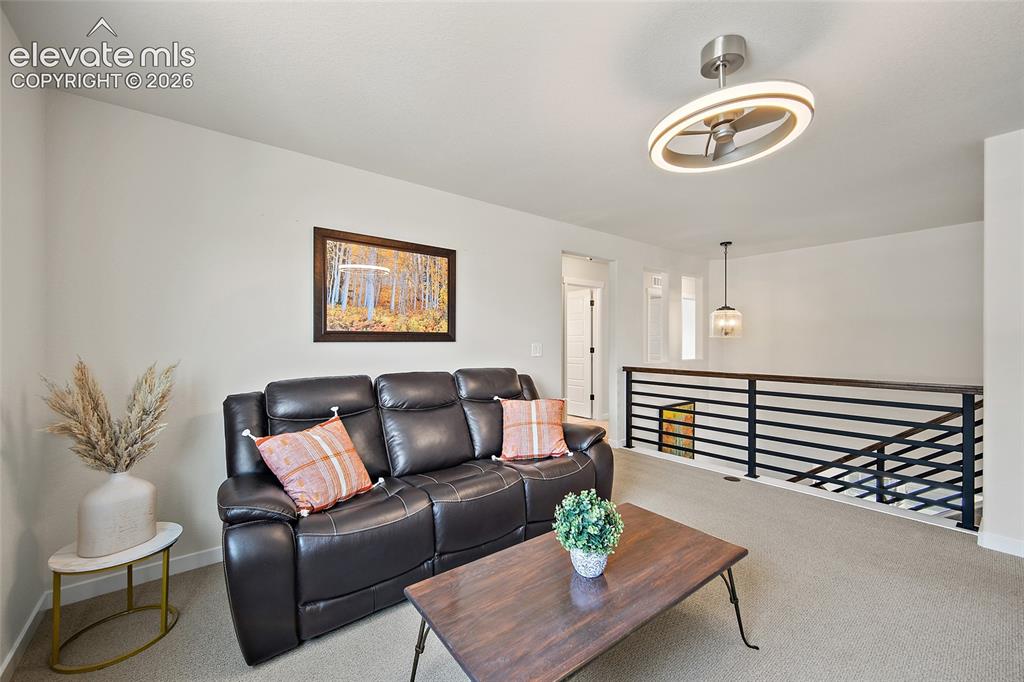 Image 29 of 47: Carpeted loft area featuring a contemporary ceiling fan with integrated lig