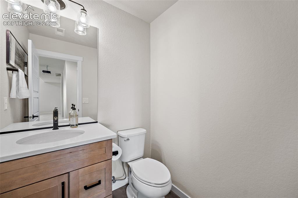 Image 37 of 47: Wood-finish vanity with black hardware, white countertop with integrated si