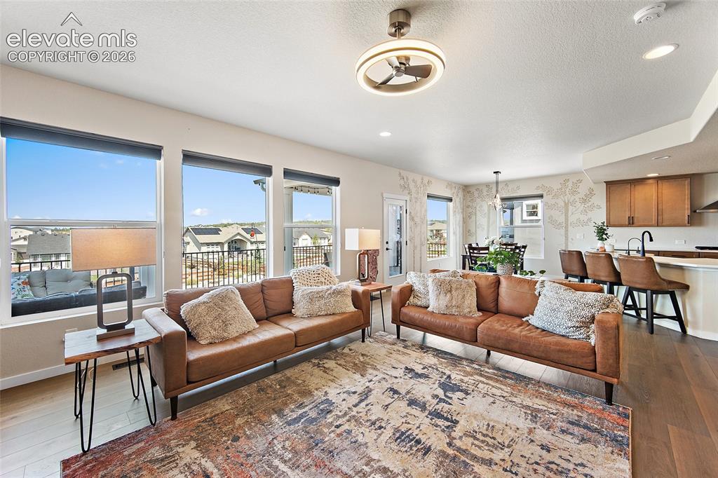 Image 4 of 47: Open-concept living area featuring wood-finish flooring, recessed lighting,