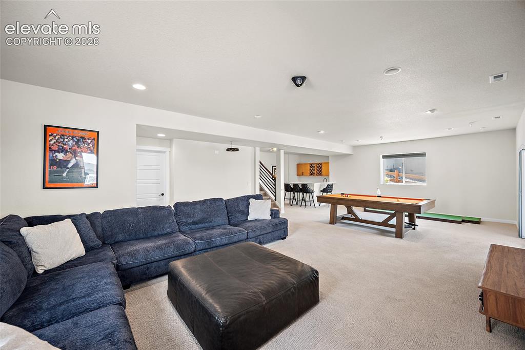 Image 41 of 47: Spacious recreation room featuring recessed lighting, a built-in wet bar wi