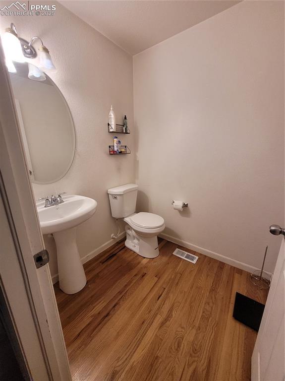 Image 5 of 17: Half bathroom featuring wood finished floors and toilet