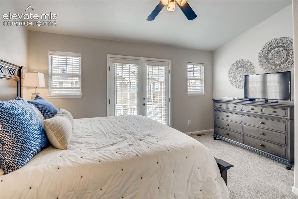 Image 12 of 23: Carpeted room featuring a ceiling fan with integrated lighting, a vaulted c