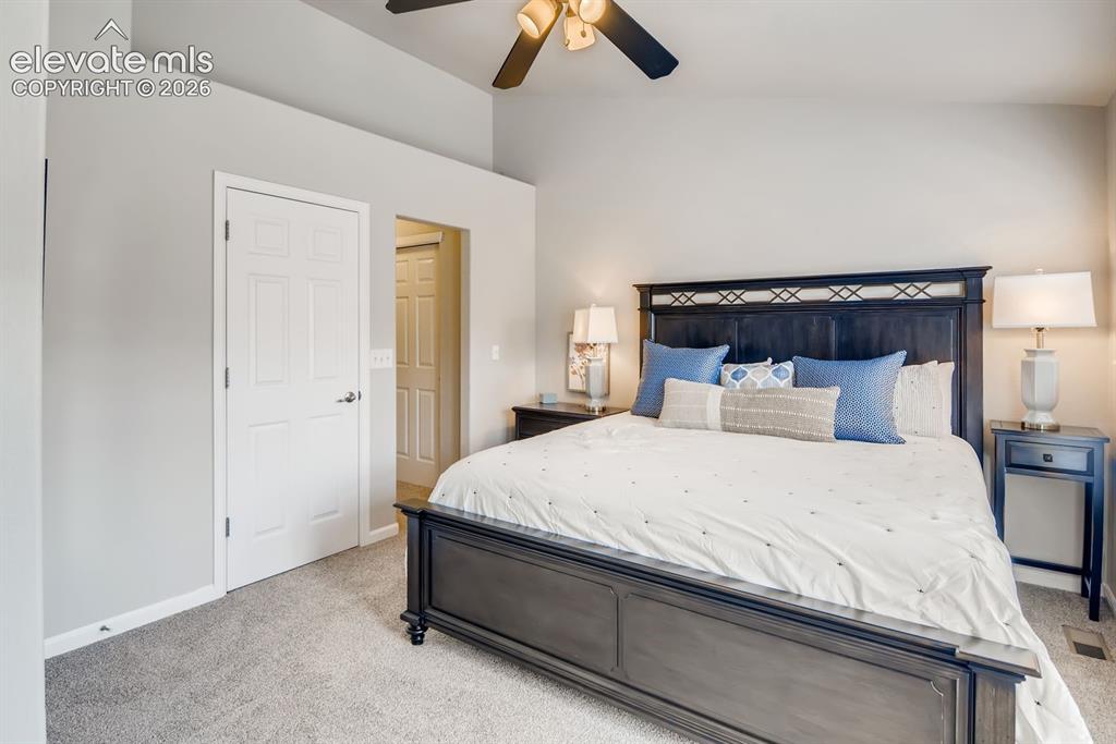 Image 13 of 23: Spacious room featuring vaulted ceilings, a ceiling fan with integrated lig