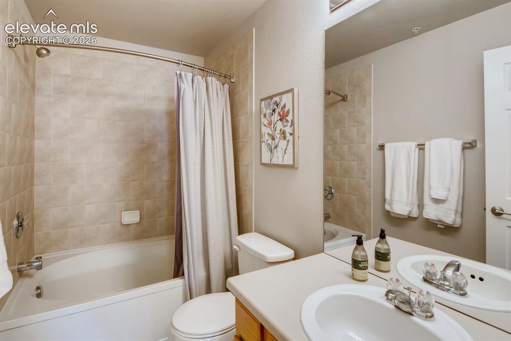 Image 14 of 23: Bathroom featuring a white bathtub, ceramic tile surround, integrated showe