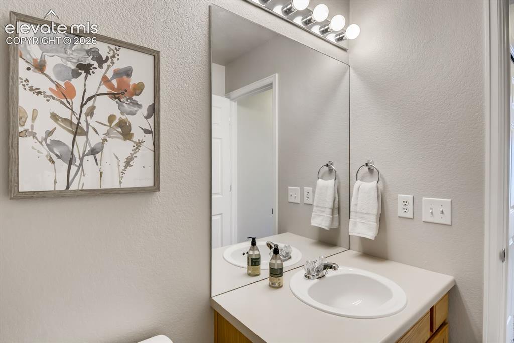 Image 15 of 23: Single vanity with an integrated oval sink and an expansive wall-mounted mi