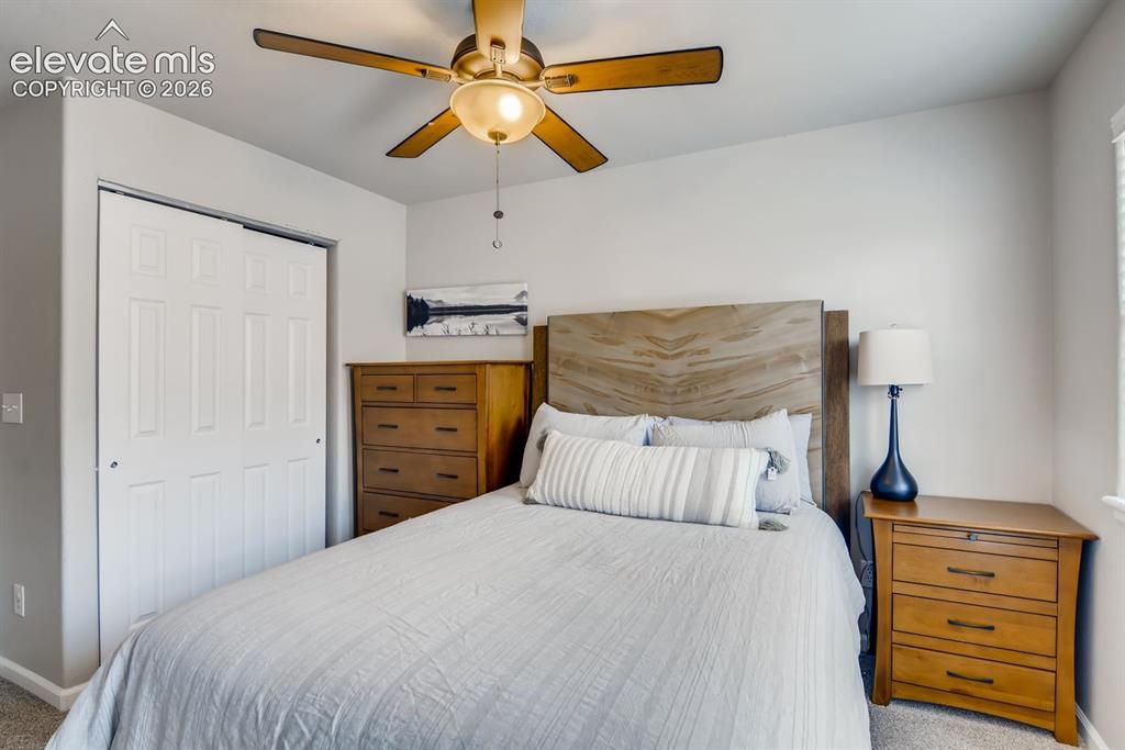 Image 16 of 23: Bedroom featuring a wood-finish ceiling fan, wood-finish headboard, and lig