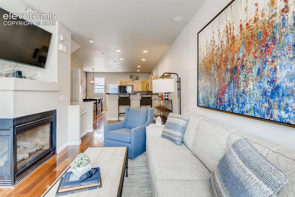 Image 5 of 23: Living area featuring a gas fireplace with a light-colored mantel and heart