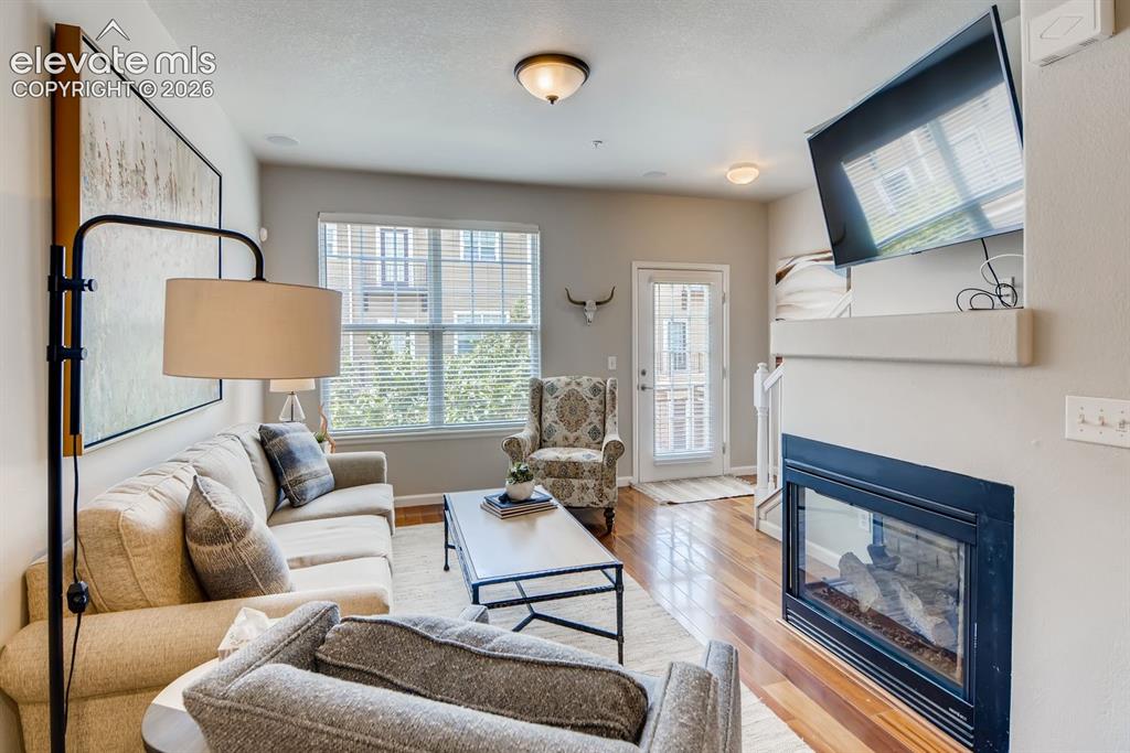 Image 6 of 23: Living area featuring wood-finish flooring, a built-in fireplace with a man