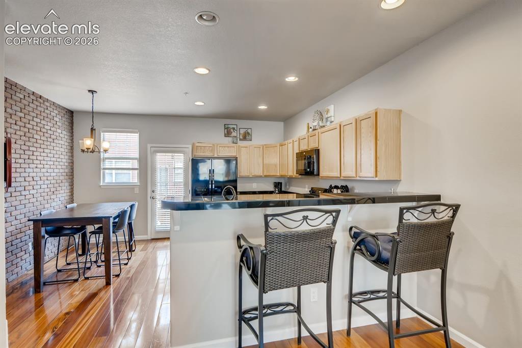 Image 8 of 23: Open-concept kitchen and dining area with wood-finish flooring